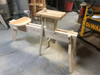 Wooden spoon mule clamp with adjustable vise and carved seat in workshop setting