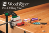 WoodRiver pen drilling vise clamping colorful pen blanks on a woodworking bench with drill bit inserted