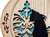Close-up of intricate scroll saw woodcut featuring floral patterns and a cat silhouette.