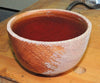 Turned wooden bowl with partially finished surface showing raw and finished wood grain
