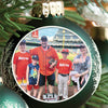 Christmas ornament hanging on pine branch featuring a photo of a family at a baseball stadium wearing Astros jerseys