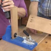 Using a Kreg pocket hole jig to drill angled pocket holes in hardwood boards for framing.