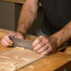 Woodworker showing proper technique using a card scraper.