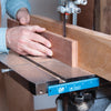 Hands guiding hardwood through bandsaw with Carter F.A.S.T. fence alignment tool attached