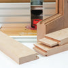 Router table setup with wooden frame and various tongue and groove joint samples displayed