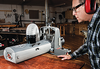Woodworker operating SuperMax 19-38 drum sander with dust collection in workshop