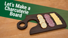 Walnut charcuterie board with handle and finger hole holding crackers, salami, and cheese slices on workshop table.