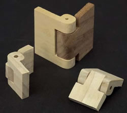 Three wooden hinges showing interlocking knuckles and a pin hole for assembly.