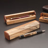 Handcrafted wooden pen presentation boxes with matching pens, showing figured wood grain and joinery details.