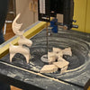 Bandsaw table with wood dust, cut wooden reindeer figure, and scrap pieces near blade.