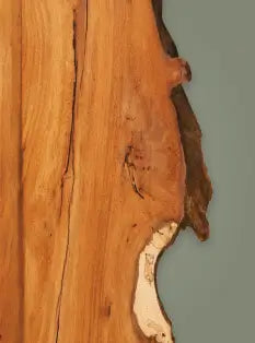 Close-up of a wooden surface with natural grain and texture on a gray background